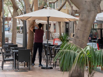 Un camarero prepara una terraza en una foto de archivo