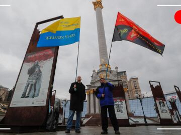 Dos hombres portando banderas de Ucrania