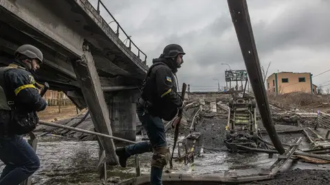 Militares ucranianos pasan junto a un puente destruido en la ciudad de Irpin, en la provincia de Kiev. Militares ucranianos pasan junto a un puente destruido en la ciudad de Irpin, en la provincia de Kiev.