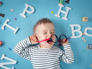 Niño rodeado de letras Niño rodeado de letras