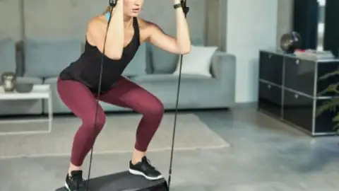 Chica entrenando con la plataforma vibratoria de Lidl Chica entrenando con la plataforma vibratoria de Lidl