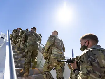 Soldados OTAN subiendo a un avión