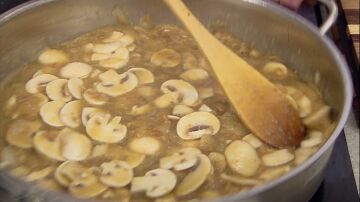 Cocina la salsa y los champiñones