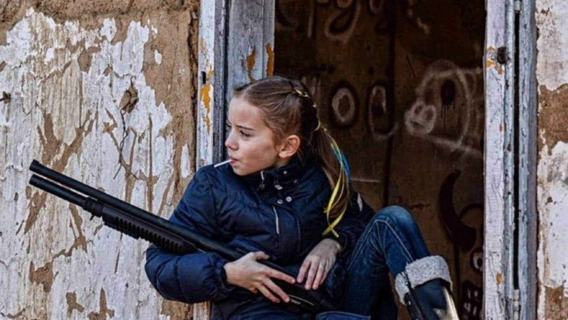 La dura imagen de una niña con una piruleta y un fusil de asalto que refleja la realidad de los más jóvenes en Ucrania