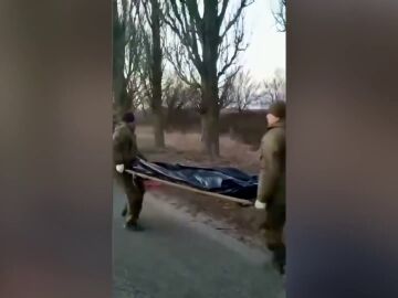 Soldados rusos llevando un cadáver en Ucrania