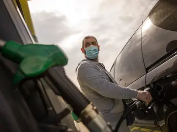 Un hombre echa gasolina a su coche Un hombre echa gasolina a su coche