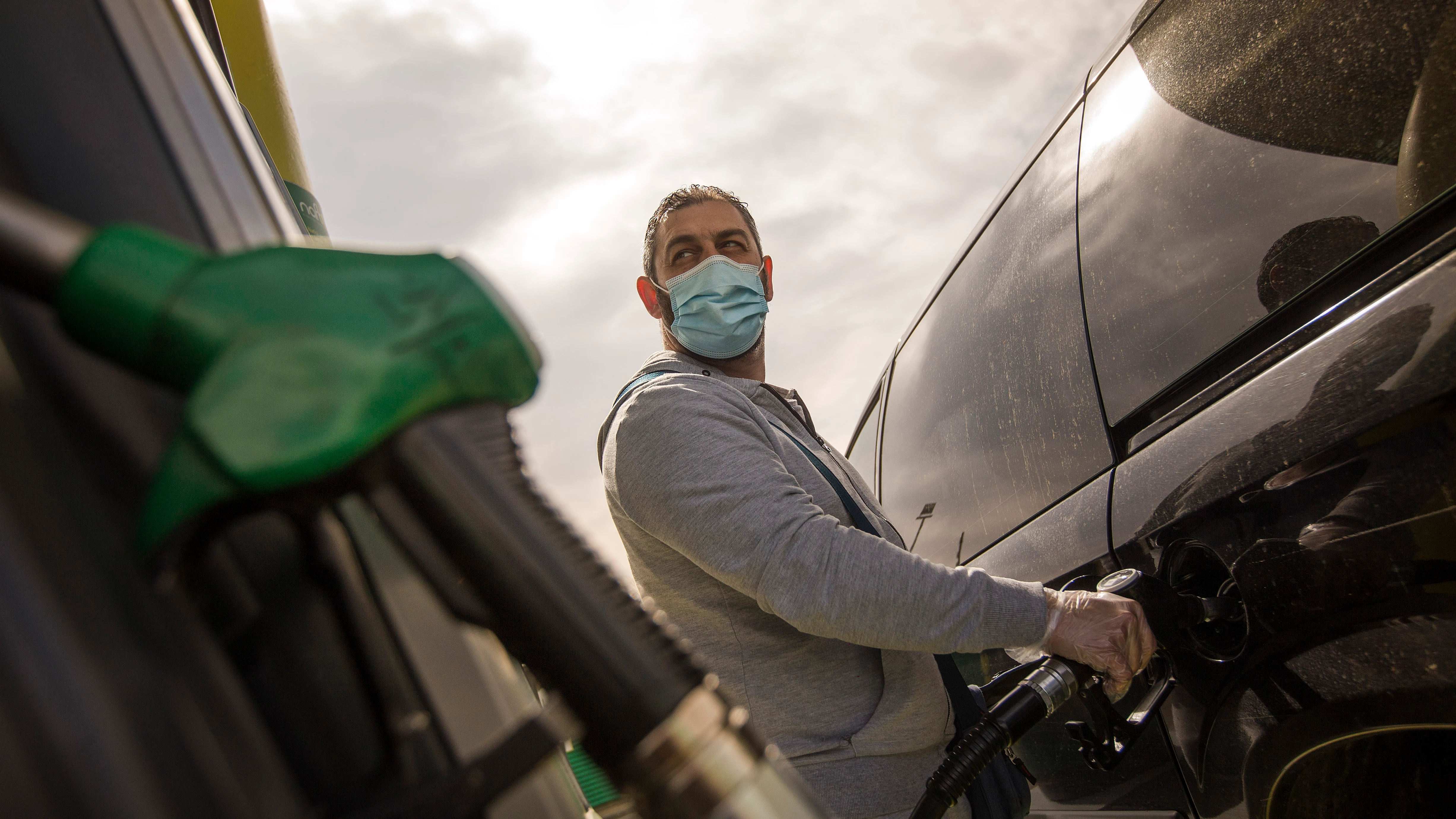Un hombre echa gasolina a su coche Un hombre echa gasolina a su coche