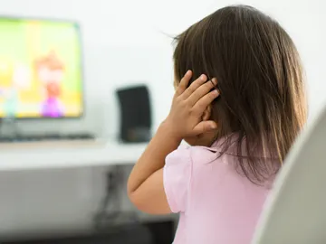 Niña tapándose los oídos Niña tapándose los oídos