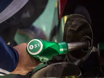 Un hombre reposta con gasolina su vehículo Un hombre reposta con gasolina su vehículo