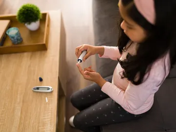 Niña pinchándose insulina. Niña pinchándose insulina.