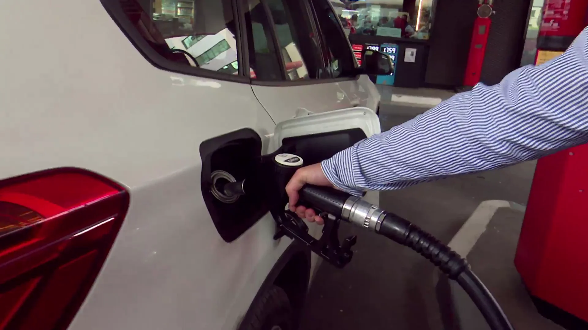Una persona echa combustible en una gasolinera