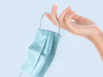 Una mascarilla en la mano de una persona Una mascarilla en la mano de una persona