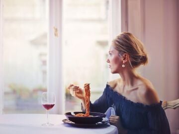 Una mujer comiendo sola.