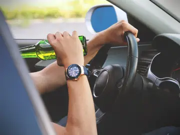 Un hombre bebe al volante Un hombre bebe al volante