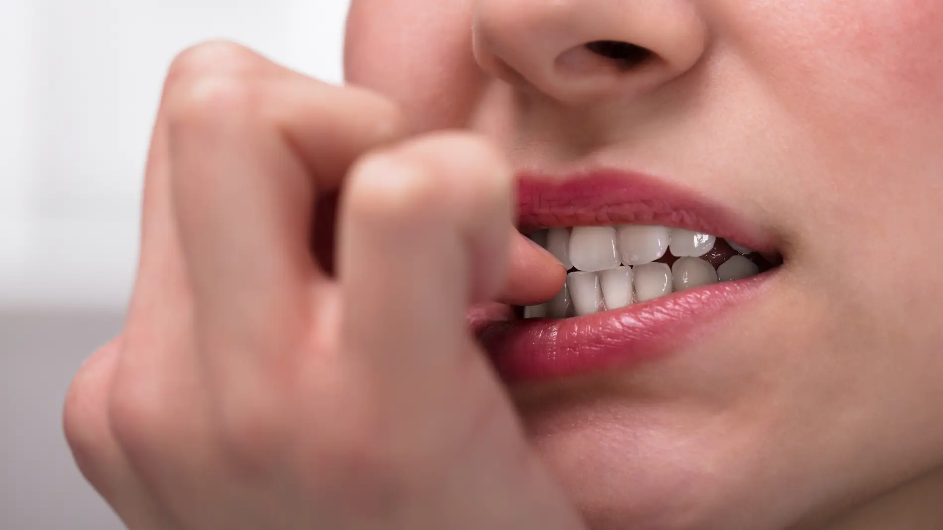 Persona mordiéndose las uñas.