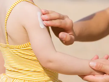 Aplicando crema solar a una niña Aplicando crema solar a una niña