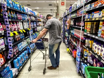 Un hombre busca productos en un supermercado Un hombre busca productos en un supermercado