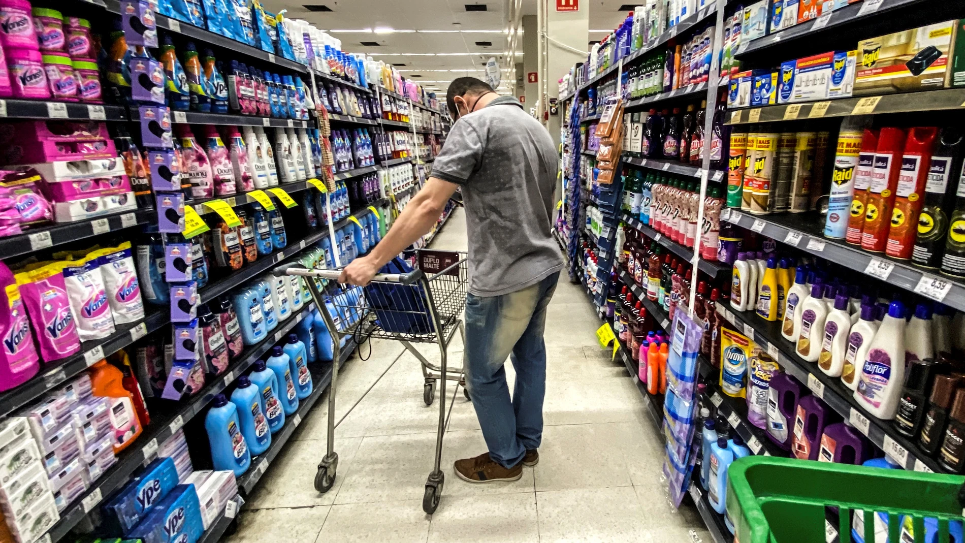 Un hombre busca productos en un supermercado Un hombre busca productos en un supermercado