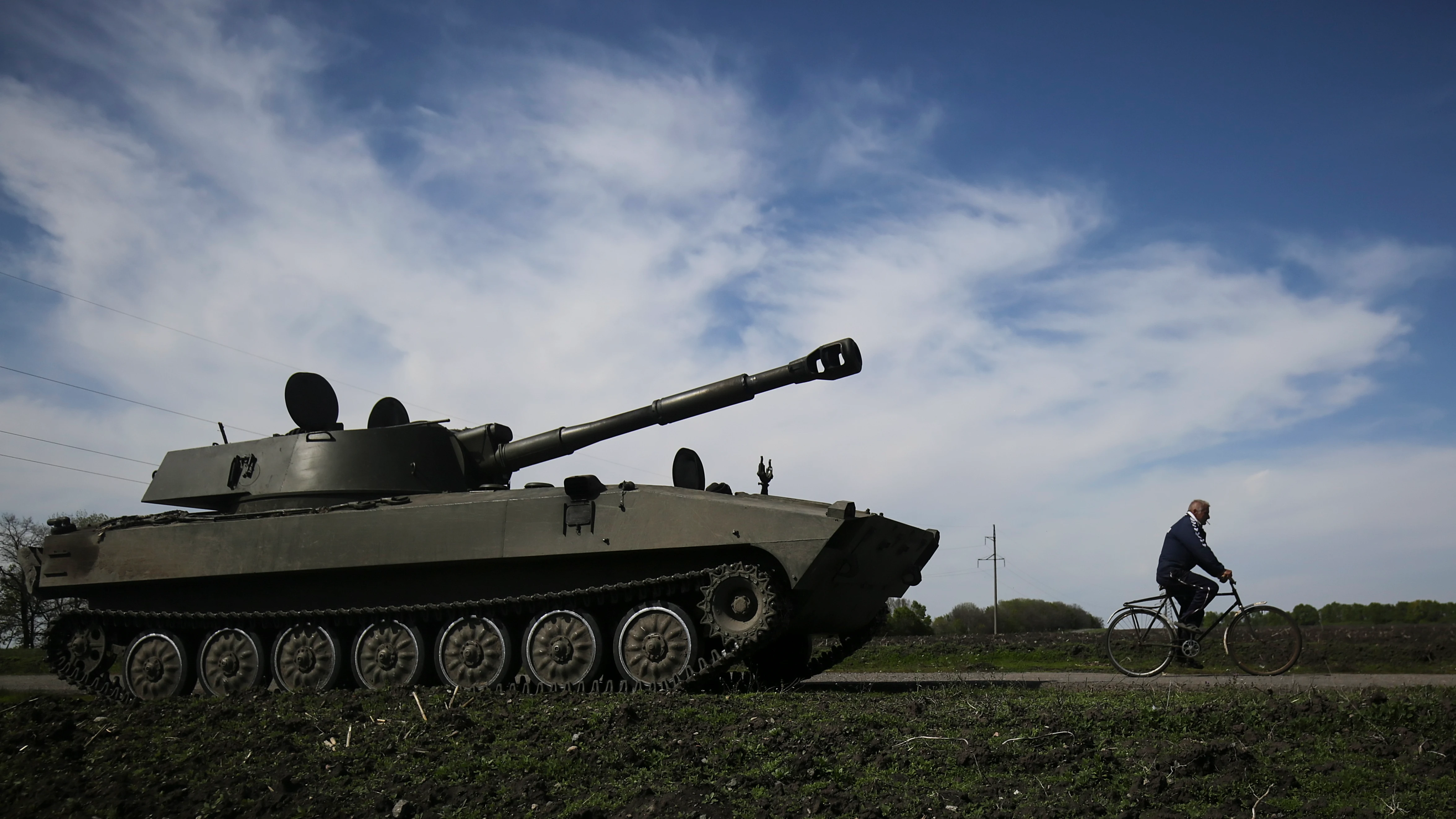 Un hombre pasea en bicicleta al lado de un tanque en la localidad ucrania de Jarkov Un hombre pasea en bicicleta al lado de un tanque en la localidad ucrania de Jarkov