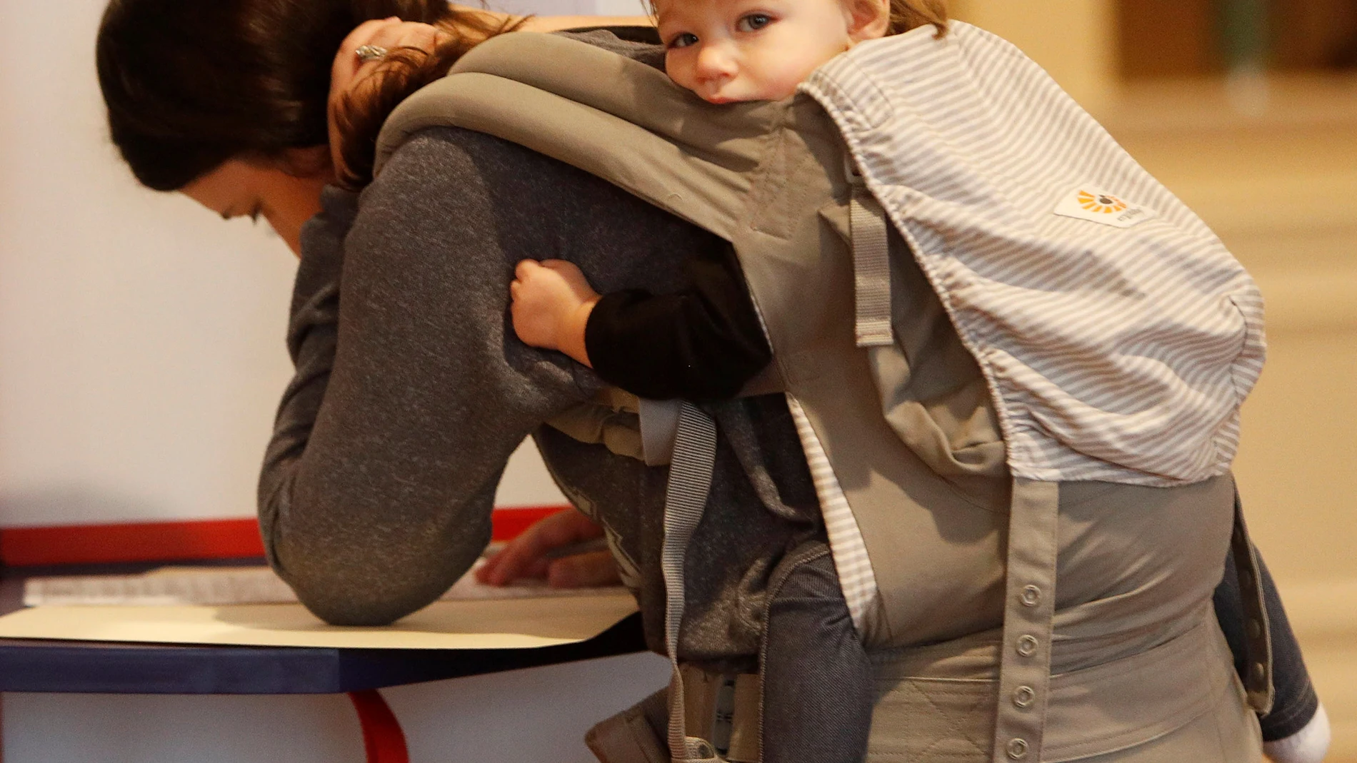 Fotografía de archivo de una mujer con su bebé mientras llenan una forma en EEUU.