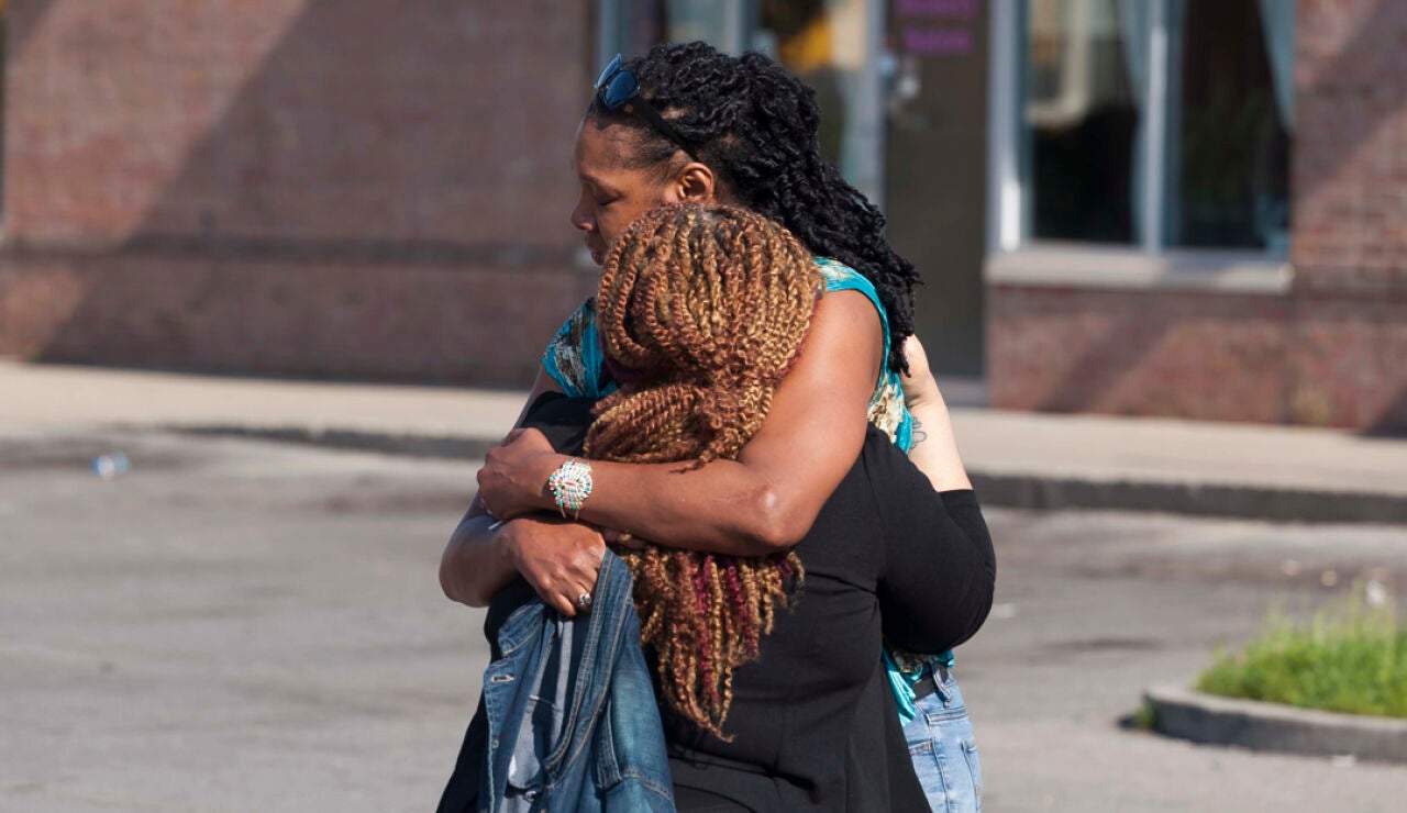 Dos personas se abrazan en el lugar del tiroteo
