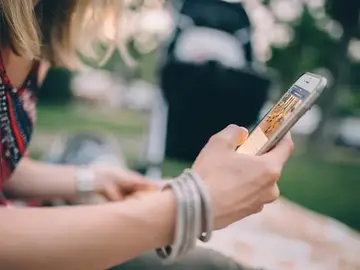 Una joven consultando el móvil Una joven consultando el móvil