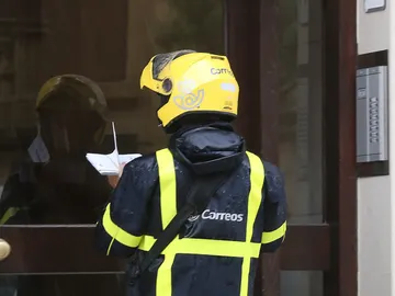 Un repartidor de Correos entrega una notificación Un repartidor de Correos entrega una notificación