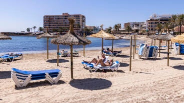 Ba&ntilde;istas toman el sol en la Playa de Palma