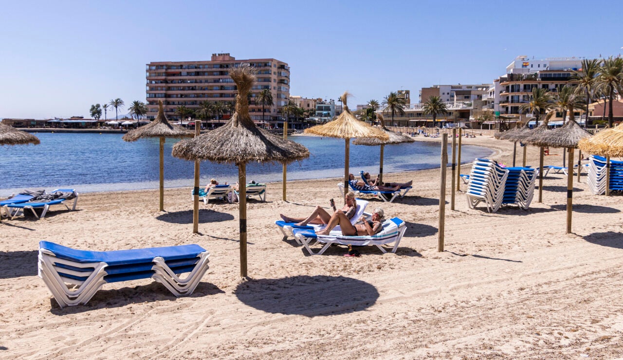 Ba&ntilde;istas toman el sol en la Playa de Palma
