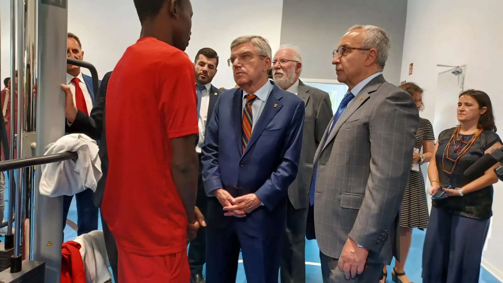 El presidente del COI, Thomas Bach, y el del COE, Alejandro Blanco, junto a un refugiado en el centro CEAR de Getafe