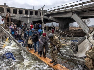 Civiles cruzan un puente destruido mientras huyen del asedio en la ciudad de Irpin