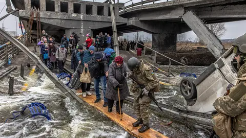 Civiles cruzan un puente destruido mientras huyen del asedio en la ciudad de Irpin Civiles cruzan un puente destruido mientras huyen del asedio en la ciudad de Irpin