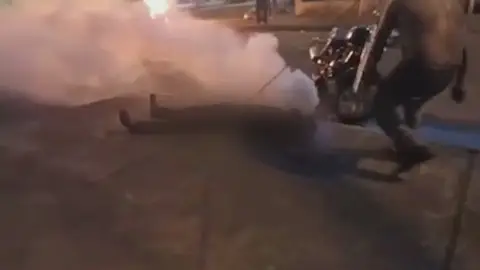 El joven rodeado de humo tras el impacto de la botella de gas lacrimógeno El joven rodeado de humo tras el impacto de la botella de gas lacrimógeno