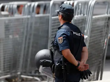 Imagen de esta semana de un policía vigilando junto a varias vallas de seguridad en Madrid