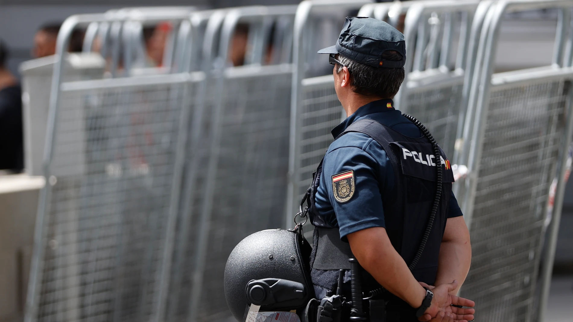 Imagen de esta semana de un policía vigilando junto a varias vallas de seguridad en Madrid