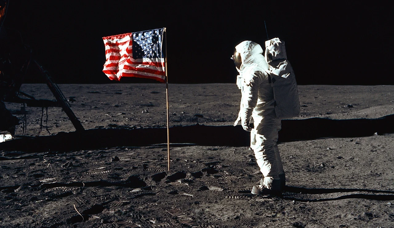 Astronauta y bandera de Estados Unidos sobre la Luna