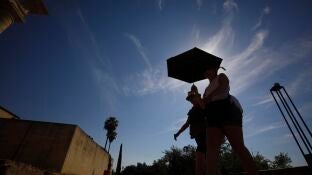 Unos turistas se protegen del sol en C&oacute;rdoba en plena ola de calor