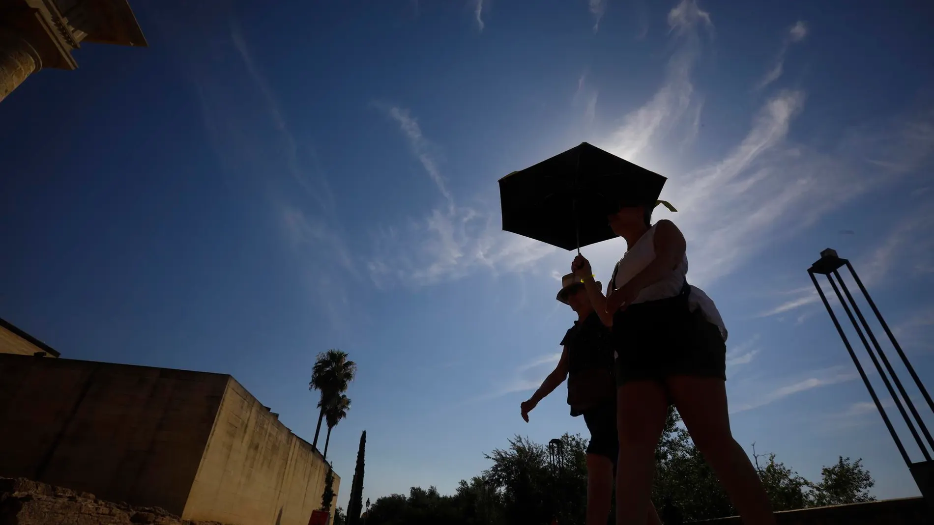 Unos turistas se protegen del sol en Córdoba en plena ola de calor