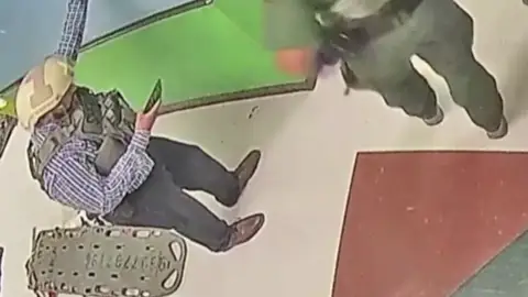 Un agente de policía usa el móvil durante el tiroteo de Uvalde Un agente de policía usa el móvil durante el tiroteo de Uvalde