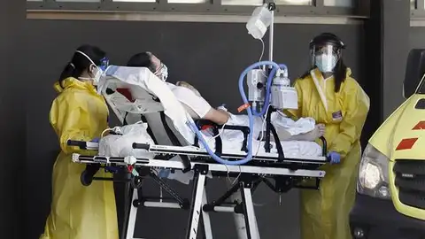 Imagen de sanitarios con un enfermo a las puertas del hospital Imagen de sanitarios con un enfermo a las puertas del hospital