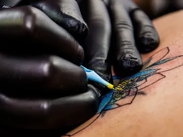 Tatuador haciendo una tatuaje Tatuador haciendo una tatuaje