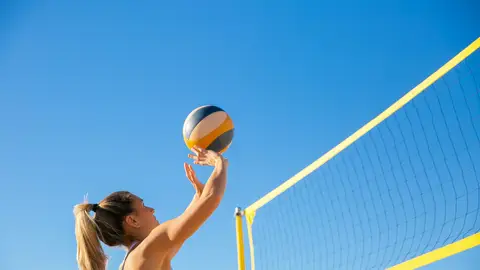 Una chica juega a voleibol en la playa. Una chica juega a voleibol en la playa.