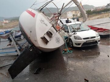 Velero caído sobre unos coches en Carnota, en A Coruña