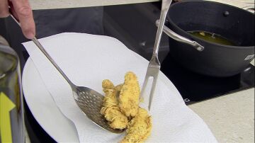 Escurre las tiras de pollo fritas