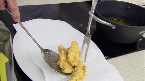 Escurre las tiras de pollo fritas Escurre las tiras de pollo fritas