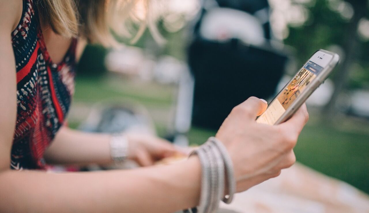 Mujer con un tel&eacute;fono m&oacute;vil en la mano