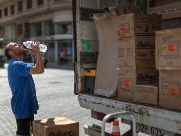 Trabajador bebe agua para combatir el calor en Valencia
