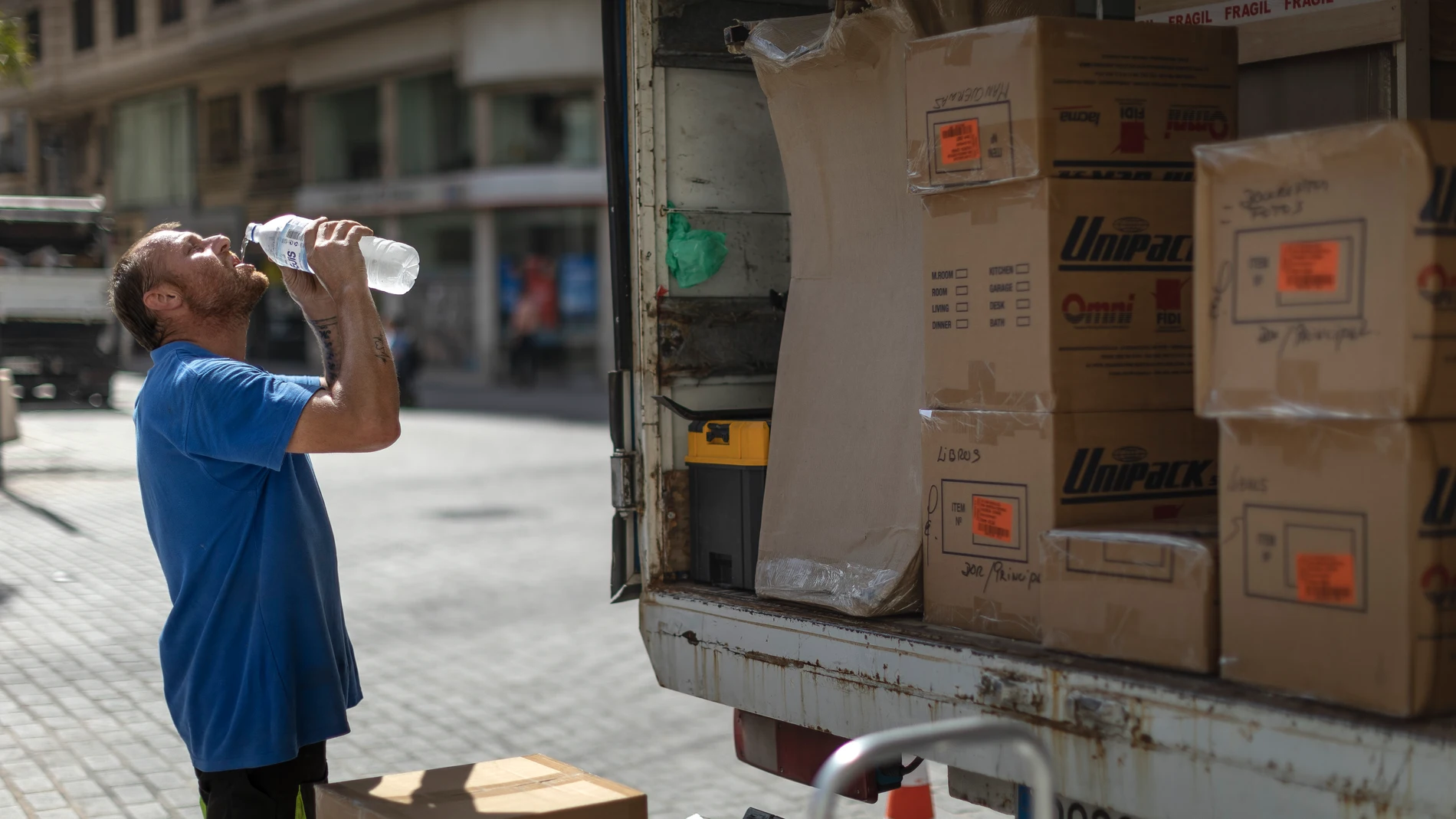 Trabajador bebe agua para combatir el calor en Valencia