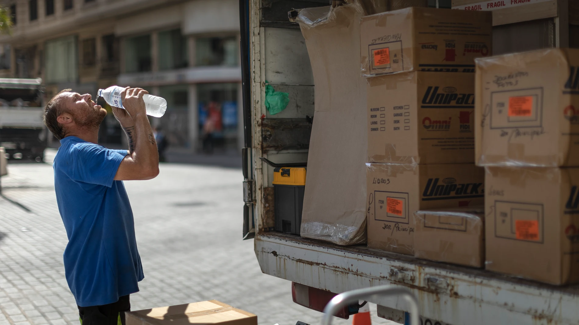Trabajador bebe agua para combatir el calor Trabajador bebe agua para combatir el calor
