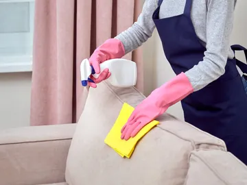 Persona limpiando un sofá Persona limpiando un sofá
